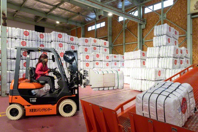 ブロック状に固められた衣類はフォークリフトで運ばれ、海外への発送準備に入る