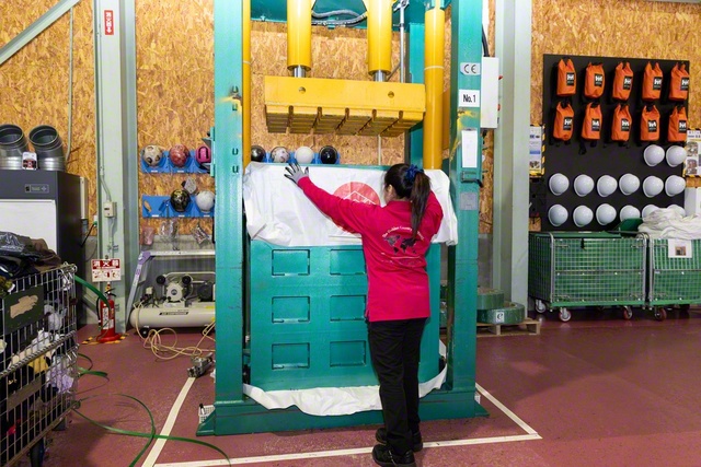 約200キログラムに及ぶ衣類を、巨大なプレス機を使って圧縮する