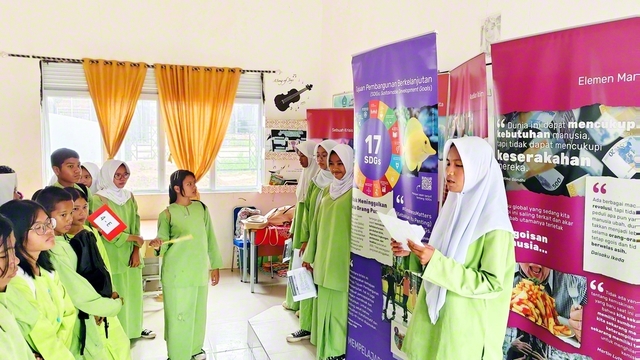 バタム市立第62中学校で行われた「希望と行動の種子」展。事前に展示内容を学んだ実行委員のメンバーが案内役を務め、同校の生徒らと語らいが広がった（バタム市内で）