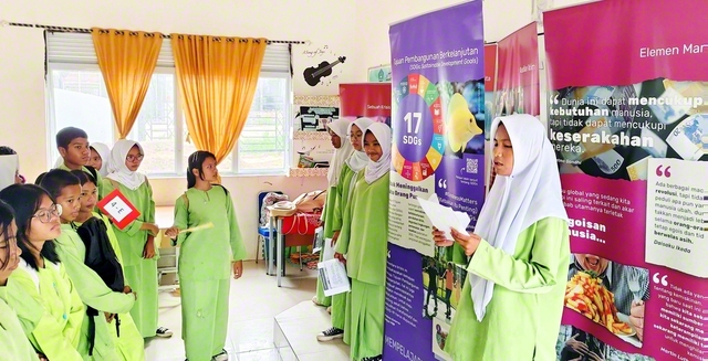 バタム市立第62中学校で行われた「希望と行動の種子」展。事前に展示内容を学んだ実行委員のメンバーが案内役を務め、同校の生徒らと語らいが広がった（バタム市内で）