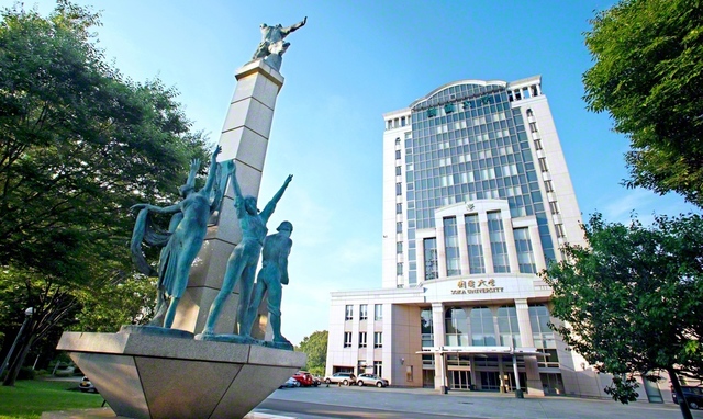 創価大学本部棟の正面に立つ「学光の塔」。「学は光、無学は闇」などの言葉が刻まれている