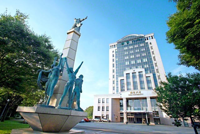 創価大学本部棟の正面に立つ「学光の塔」。「学は光、無学は闇」などの言葉が刻まれている