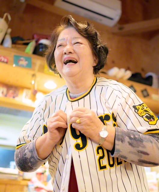 阪神タイガースのユニホームを着ると、とびきりの笑顔になるあや子さん。「今季もいい戦力が入ったのよ」とうれしそう