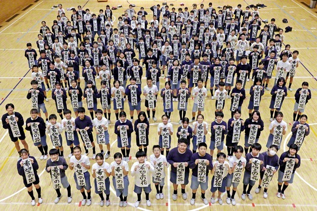 書き初め大会に挑んだ関西創価小学校の5、6年生が記念のカメラに（9日）