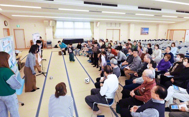 歓喜あふれる千葉・ユトリシア地区の座談会。未来っ子たちと一緒に代表が今年の決意を漢字一文字で披露し、笑顔の花が咲いた（習志野文化会館で）