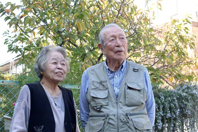 安藤さんを陰に陽に支える吉田さん㊧とサクランボの木の前で。対話に打って出る安藤さんの姿を誰よりも喜んでいる