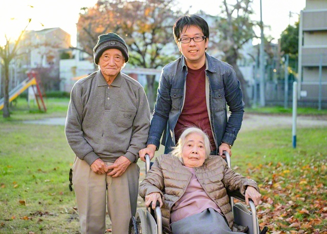 大阪府内の旅行会社で働く山本正広さん（後列右）。共に暮らす父・大造さん（同左）、母・和子さんと共に