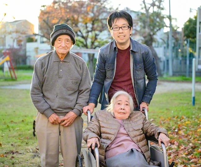 大阪府内の旅行会社で働く山本正広さん（後列右）。共に暮らす父・大造さん（同左）、母・和子さんと共に