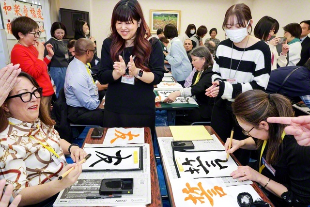東京・世田谷を訪れたアメリカの同志が、書道体験を楽しむ（同日、東京池田記念講堂で）