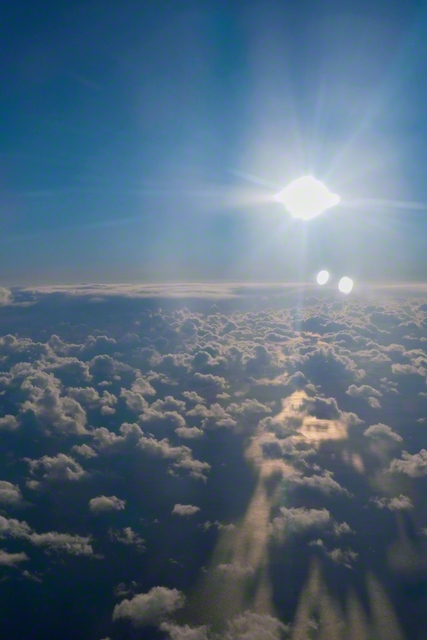 冬の空に赫々と昇る太陽が、太平洋と雲を照らす（北海道苫小牧市から南に約60キロ。東京から札幌に向かう機中から撮影）