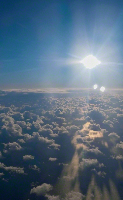 冬の空に赫々と昇る太陽が、太平洋と雲を照らす（北海道苫小牧市から南に約60キロ。東京から札幌に向かう機中から撮影）