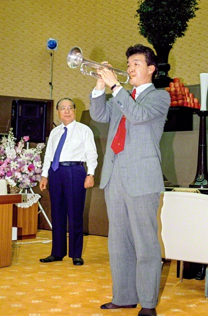 トランペッターの大野俊三さんが「オーバー・ザ・レインボー」の演奏を披露。交通事故の試練を乗り越えた弟子の雄姿を、池田先生がそばで見守った（1991年3月12日、中部池田記念講堂で）