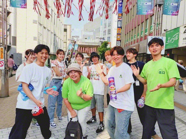 昨年7月に八王子駅北口で行われた七夕まつりで、八王子駅北口商店会会長の清水栄さん（前列左から2人目）が創大・西川ゼミの学生らと、にこやかに