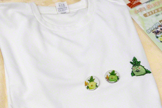 「くわるん」のオリジナルTシャツと缶バッジ