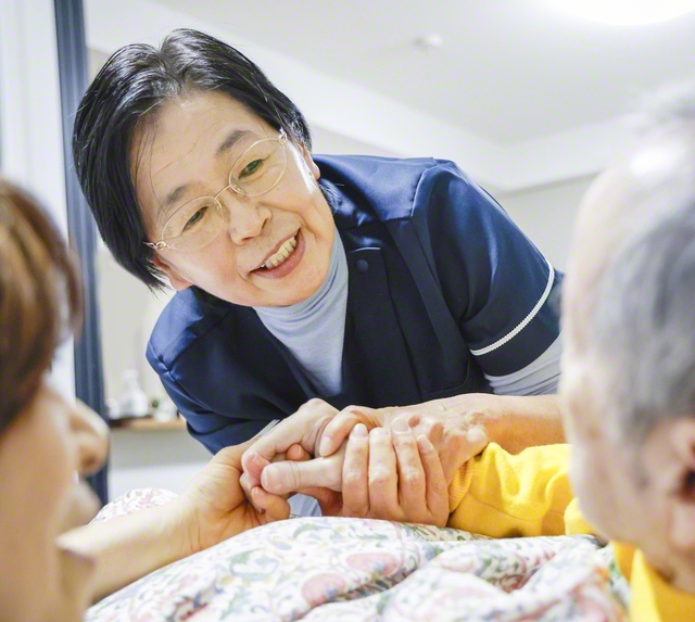 利用者の手を取り、目線を合わせてケアをする星さん。そのぬくもりが相手の不安を取り除き、安心をもたらす