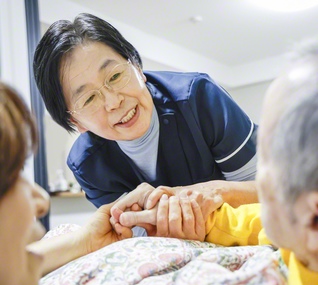 利用者の手を取り、目線を合わせてケアをする星さん。そのぬくもりが相手の不安を取り除き、安心をもたらす