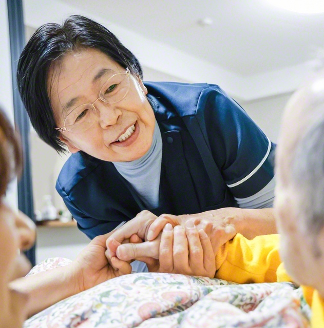 利用者の手を取り、目線を合わせてケアをする星さん。そのぬくもりが相手の不安を取り除き、安心をもたらす