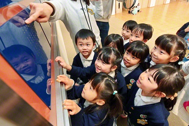 自分の名前を見つけ、瞳を輝かせる園児たち（札幌創価幼稚園で）