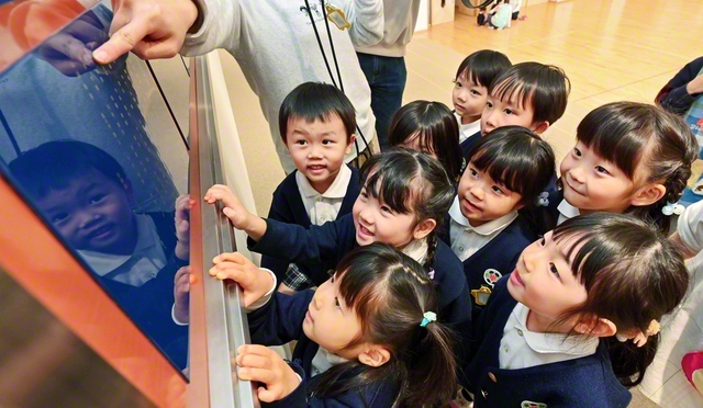 自分の名前を見つけ、瞳を輝かせる園児たち（札幌創価幼稚園で）