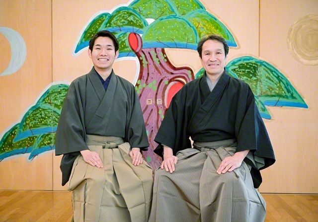 小笠原由祠さん㊨と長男の小笠原弘晃さんが稽古場で。背景の老松は由祠さんが自ら描いた