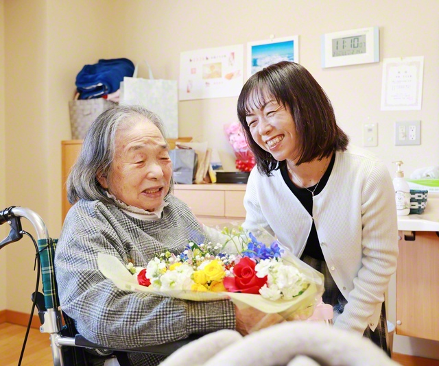 今月23日に、79歳の誕生日を迎える母・さちよさん㊧へ、加藤さんが祝福の花束を。さちよさんは認知症を患い、特別養護老人ホームで暮らしている（長野県松本市内で）