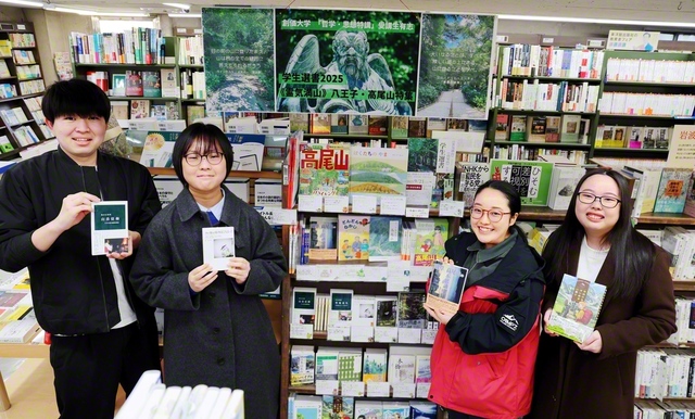 高尾山に関連した書籍を扱う「学生選書コーナー」で、携わった創価大学生が本を手に。昨年9月から先週末まで実施され、好評を博した