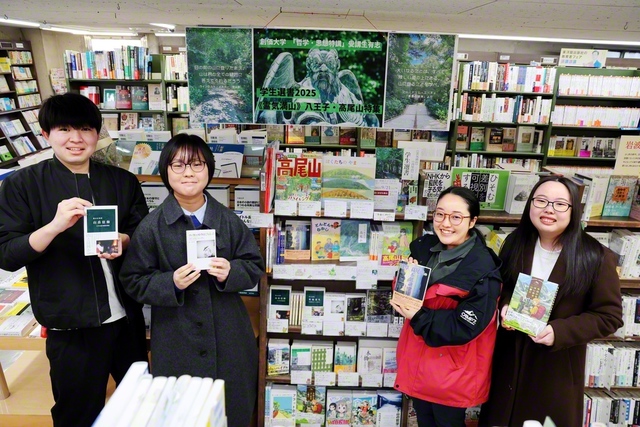 高尾山に関連した書籍を扱う「学生選書コーナー」で、携わった創価大学生が本を手に。昨年9月から先週末まで実施され、好評を博した