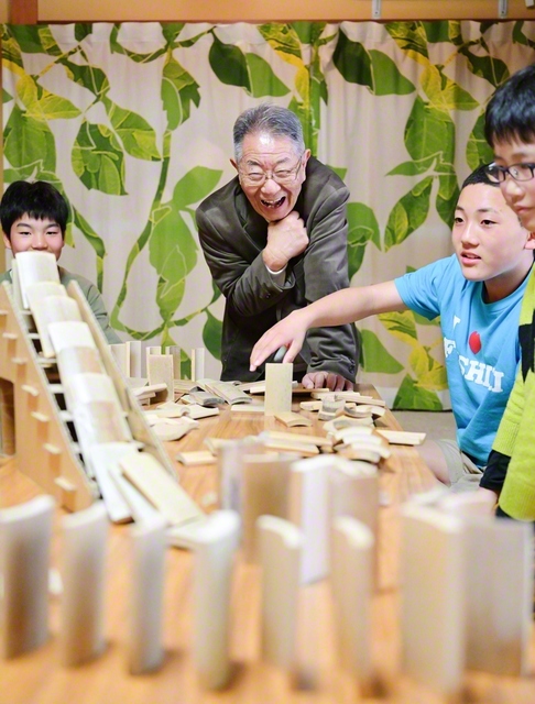 子どもたちと「竹ドミノ」で笑い合う西村さん（中央）