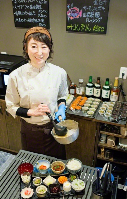 「日替わり腸活御膳」を盛り付ける原山さん。みそ汁を飲み、「優しい味がする」と涙を流したお客もいたという