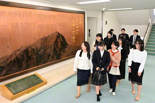 総会に集った青年世代が大分平和会館に設置された長編詩の詩碑の前で