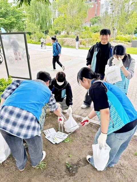 掃除用具を片手にゴミ拾いに取り組む韓国SGIの学生部メンバー