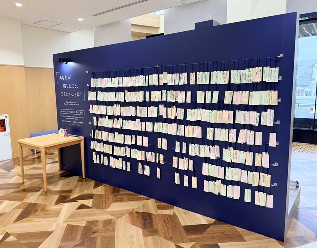 宮古市災害資料伝承館のエントランス。津波の脅威を物語る案内標識が設置されているブースの裏側には、“復興への願い”や“記憶を未来につなげる決意”など、来館者がつづった短冊が飾られている（岩手・宮古市田老で）