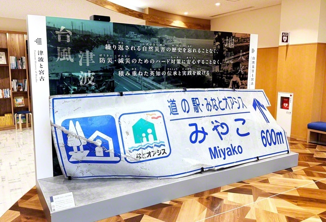 宮古市災害資料伝承館のエントランス。津波の脅威を物語る案内標識が設置されているブースの裏側には、“復興への願い”や“記憶を未来につなげる決意”など、来館者がつづった短冊が飾られている（岩手・宮古市田老で）