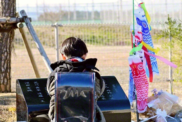 慰霊碑に隣接する閖上小中学校の児童が碑に手を合わせる（今月11日の午後3時過ぎ）
