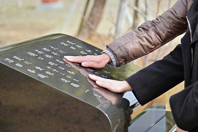 宮本さんと橋浦さんが慰霊碑をなでる