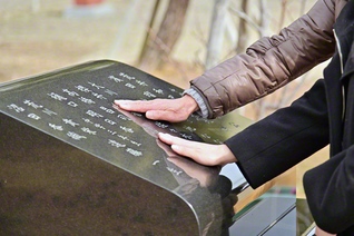 宮本さんと橋浦さんが慰霊碑をなでる