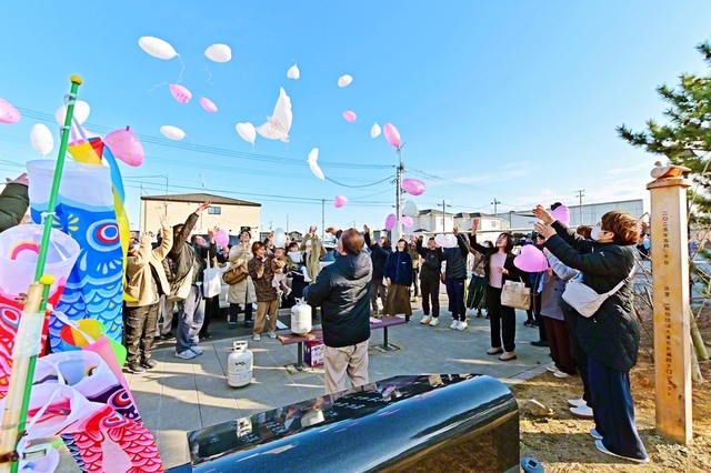 閖上中学校・慰霊碑の前に、震災当時の教員や卒業生、遺族会の方々などが集まって、追悼のメッセージを書いたハト型の風船を空に放った（今月11日）
