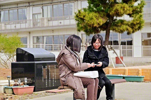 橋浦なぎささん㊨に、手紙入りの封筒を渡す宮本さん（今月10日、閖上中学校・慰霊碑前で）