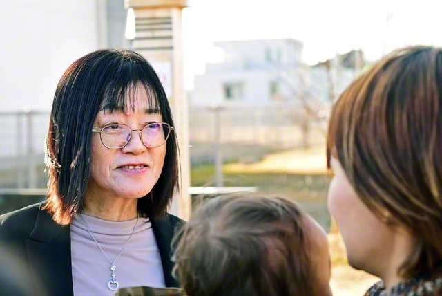 宮本靜子さん㊧が慰霊碑の前で、1歳の子どもを連れた卒業生と