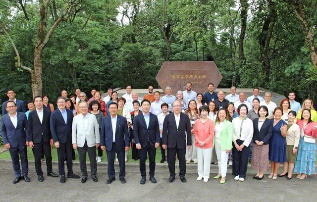 谷川SGI理事長、那須同女性部長と各国の代表が、「南米広布原点の地」の碑の前で記念のカメラに（15日、ブラジルSGI自然文化センターで）