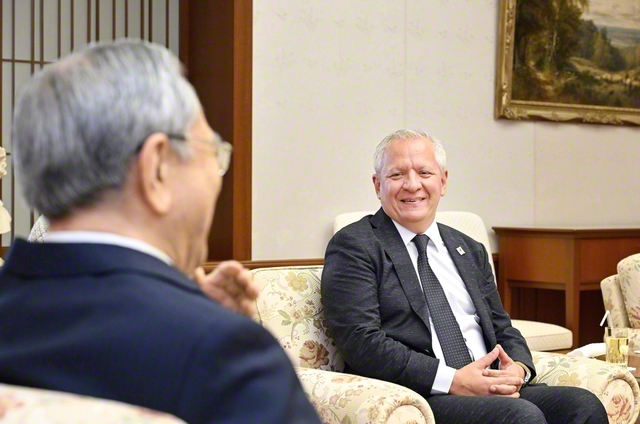 池田大作国際平和研究センターのネグレティ学術所長㊨と原田会長の会見は終始和やかに（創大池田記念講堂で）