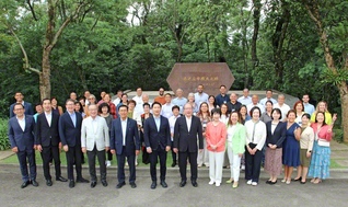 谷川SGI理事長、那須同女性部長と各国の代表が、「南米広布原点の地」の碑の前で記念のカメラに（15日、ブラジルSGI自然文化センターで）