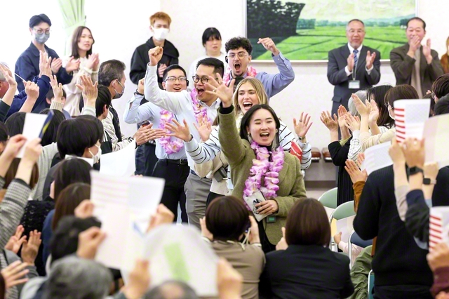 盛大な歓迎に、笑顔で手を振るアメリカの友。茶道や習字などの日本文化にも触れ、友情を育んだ。集いでは未来部員が元気に合唱を披露した（島根・出雲文化会館で）