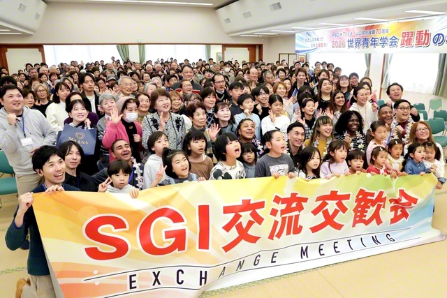 未来っ子たちが元気いっぱいに歓迎した山口・下関文化会館での集い。アメリカSGIのハックマン男子部長が来日したメンバーを紹介し、歓迎への感謝の言葉を述べた