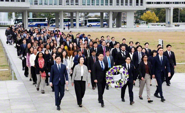 アメリカ青年部、日本の青年世代の代表が原爆死没者慰霊碑に献花。題目三唱の時刻は、原爆投下と同じ8時15分。メンバーが顔を上げると「平和の時計塔」の鐘が鳴り響いた（広島市内で）