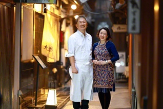 店の前に立つ藤林さん㊧と妻・友子さん。ここは祇園のど真ん中。店は接待にも多く使われるというが、「実家みたいに和んでほしい」と。父の心を追う旅は、終わりがないから面白い