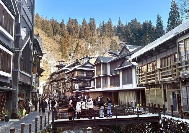 国内外の観光客でにぎわう銀山温泉街。足湯や共同浴場もあり、日帰り客も自慢の温泉を楽しめる。近くには、かつての銀山の面影を感じられる銀坑洞や高さ22メートルの白銀の滝なども