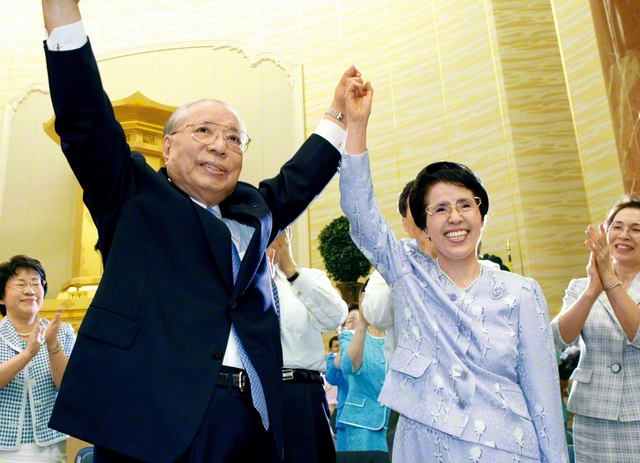 広宣流布に尽くす不二の同志に幸福と勝利あれ――力強く手を挙げ、友を鼓舞する池田先生ご夫妻（2005年9月、東京で）