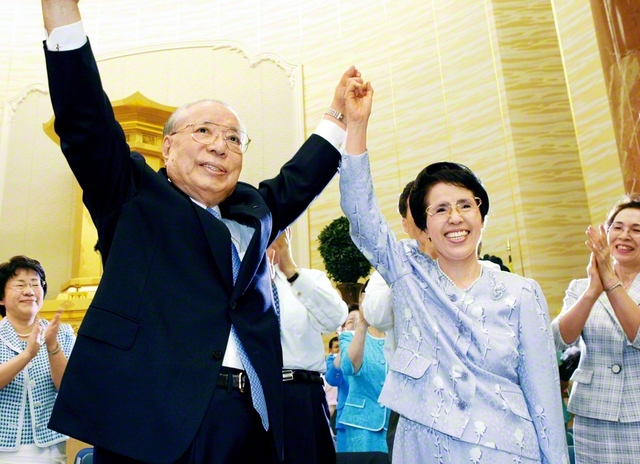 広宣流布に尽くす不二の同志に幸福と勝利あれ――力強く手を挙げ、友を鼓舞する池田先生ご夫妻（2005年9月、東京で）