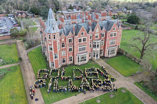 創価の城を守りゆくイギリス壮年部が「GOLDEN　PILLARS（黄金柱）」の人文字を鮮やかに（14日、タプロー・コート総合文化センターで）